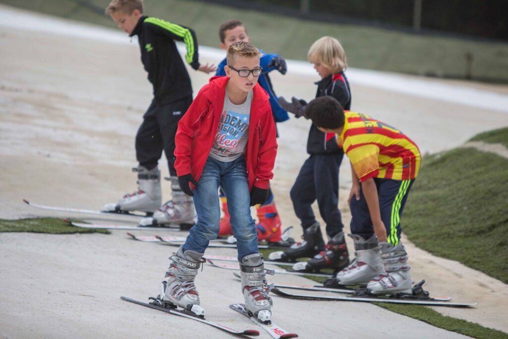 Kinderen oefenen skiën op een indoor skibaan