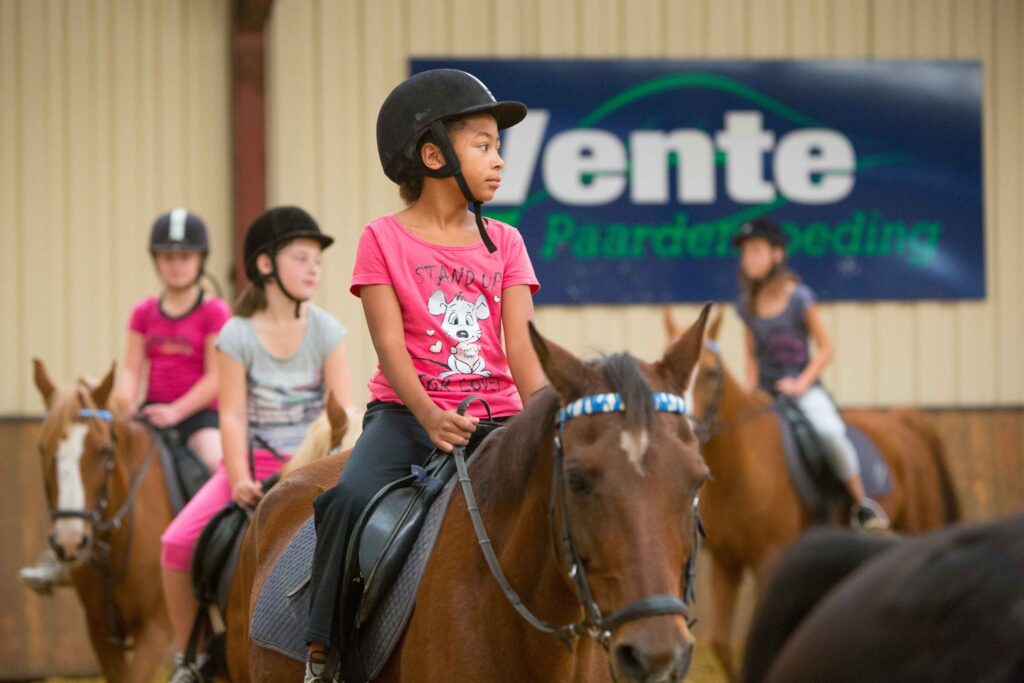 Kinderen paardrijden tijdens een begeleide activiteit