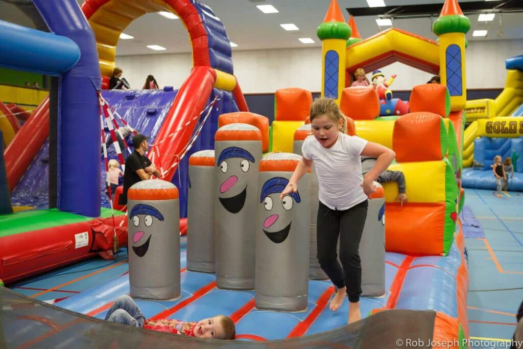 Kinderen spelen op een groot rood en geel springkussen