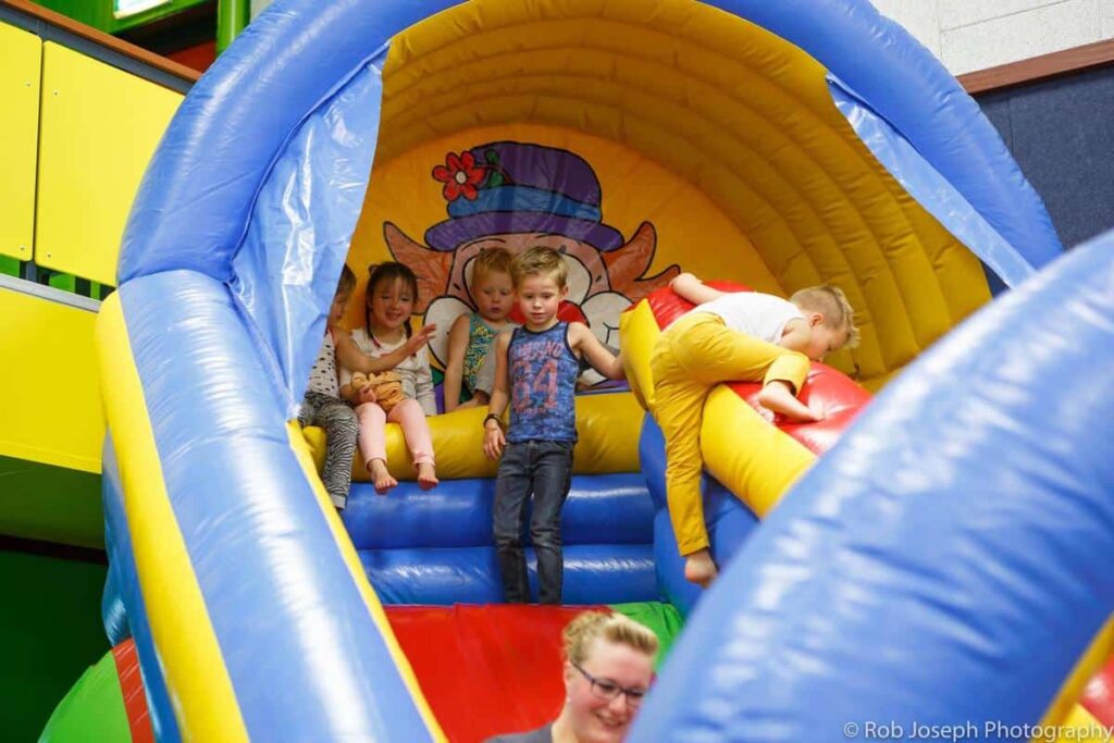 Kinderen spelen in een groot kleurrijk opblaasbaar speeltoestel